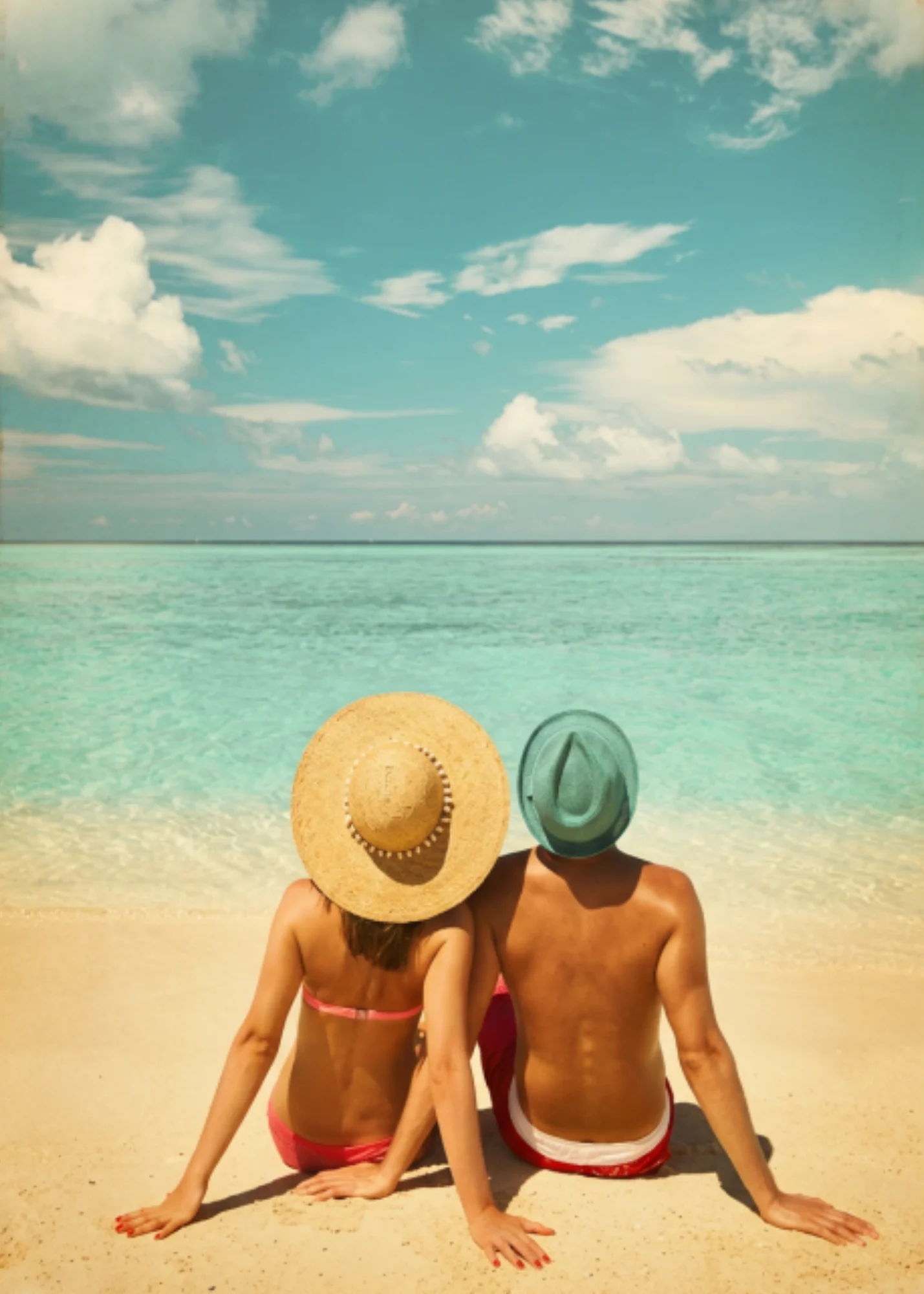 Pareja sentandos en una playa caribeña de Cancún.
